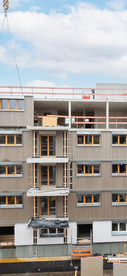 Vorgefertigte Wandelemente aus Holz werden mit Hilfe eines Krans montiert | © Christoph Wacker