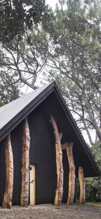 A small chapel made of dark wood surrounded by trees | © Alessandra Chemollo