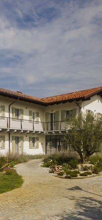 Casa a due piani con tetto di tegole rosse, facciata imbiancata e scuri di colore verde chiaro | © Alessandro Santi