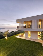 Una moderna villa di due piani con grandi vetrate e tetto piano