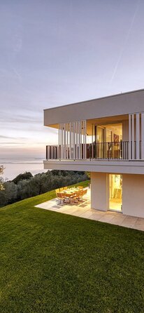 Una moderna villa di due piani con grandi vetrate e tetto piano