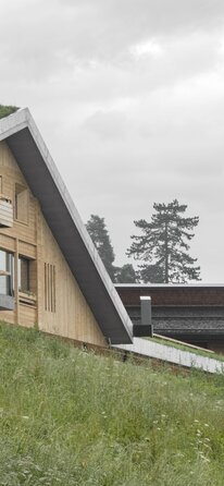n a green meadow stands a new house with walls made of natural wood and a green roof | © Gustav Willeit