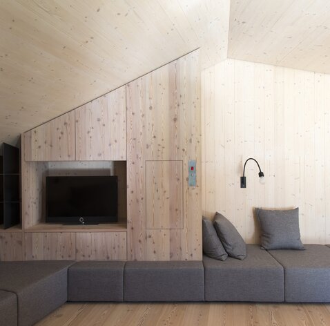 Interni chiari con pareti in legno e un tetto inclinato in legno a vista