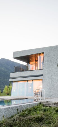 Un facciata di un edifico moderno con facciata in cemento a vista e vetro