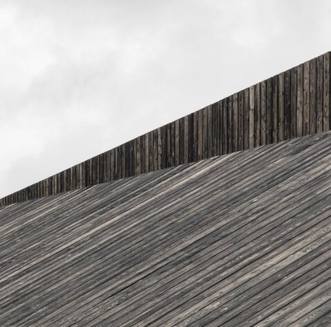 Ein Dach, das mit schwarzen Bretten aus Holz verkleidet ist | © Gustav Willeit