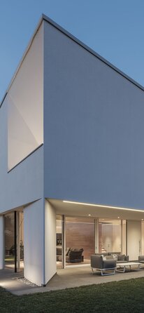 Eine moderne Villa mit verputzter Außenfassade und großen Fensteröffnung | © Davide Perbellini