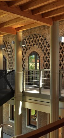 Vista interna di un edificio industriale ristrutturato con tetto in legno | © Arch. Paolo Bedogni