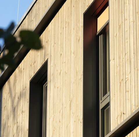 Detailaufnahme einer Fassade aus vorvergrautem Holz | © Carolin Hirschfeld