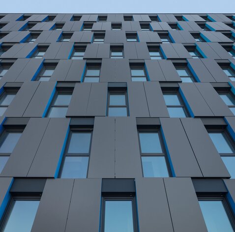 Eine moderne Fassade eines achtstöckigen Gebäudes | © Regina Sedlmayer