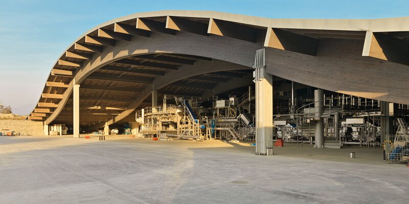 Eine große Halle mit einem geschwungenen Dach mit einer tragenden Struktur aus gebogenen Trägern aus Brettschichtholz | © Matteo Piazza
