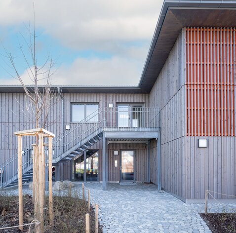 Facciata ventilata di una scuola con rivestimento in legno effetto invecchiato | © Florian Holzherr