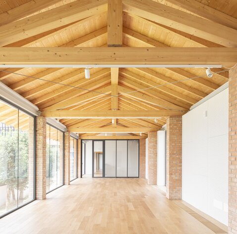 Una stanza profonda con un tetto fatto di capriate in legno a vista | © Federico Villa