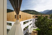 A school building, on top of the three plastered basement floors there is a fourth floor with a cladding of larch wood | © Samuel Holzner