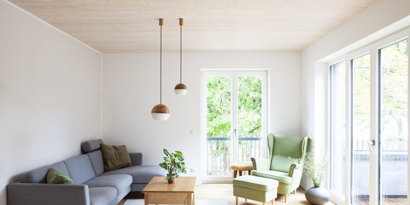 Ein modern gestaltetes Wohnzimmer mit Boden und Decke aus Holz | © Regina Sedlmayer