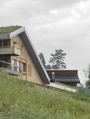 In einer grünen Wiese steht ein neues Haus mit Wänden aus naturbelassenem Holz und einem begrünten Dach aus Beton | © Gustav Willeit