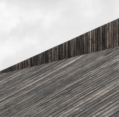 Ein Dach, das mit schwarzen Bretten aus Holz verkleidet ist | © Gustav Willeit