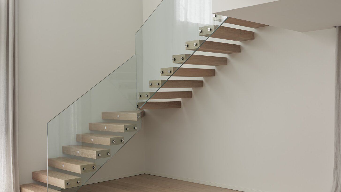 Eine freitragende zweiläufige Treppe mit Stufen aus Holz und einem Glasgeländer | © Davide Perbellini