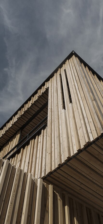 A building covered on the outer façade with a formwork of larch wood strips | © Mariano Dallago