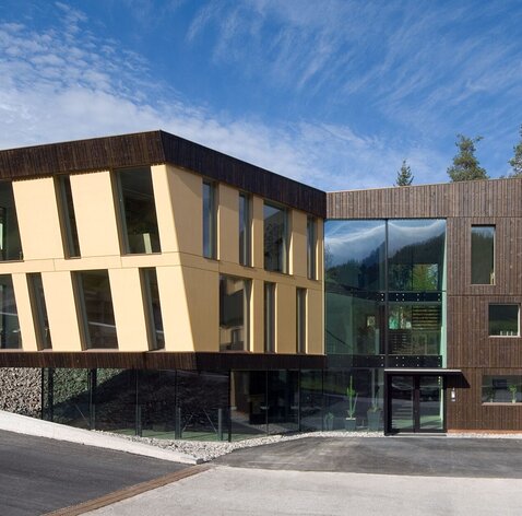 Un edificio moderno con grandi vetrate e un rivestimento in legno scuro e pannelli gialli