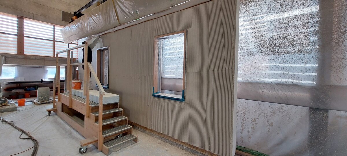 Aufbringen des Grundputzes in der Vorfertigungshalle | © LignoAlp